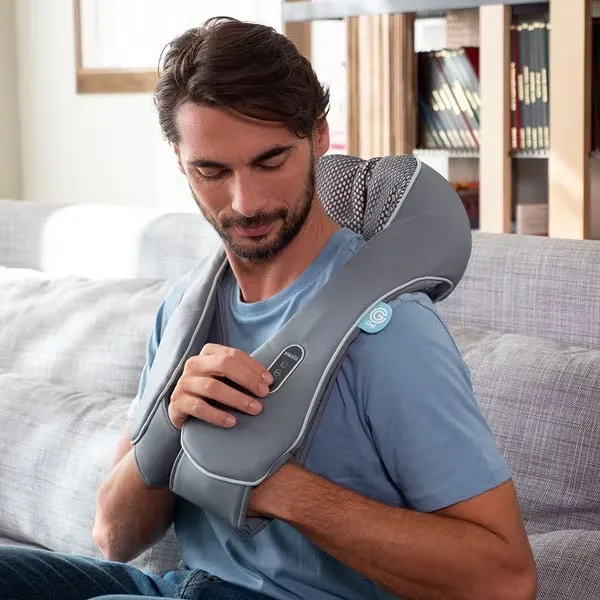 A man is using a neck and shoulder massager while sitting on a sofa. (Image: HoMedics) A man is using a neck and shoulder massager while sitting on a sofa.
