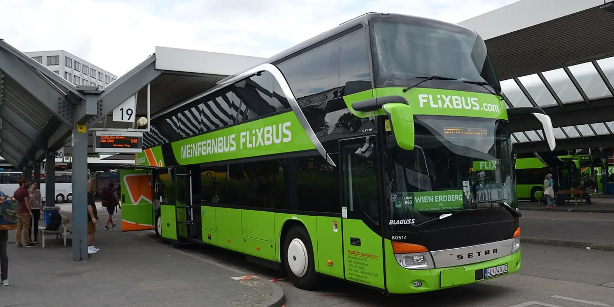 A FlixBus double-decker bus at a bus stop. A FlixBus double-decker bus at a bus stop.