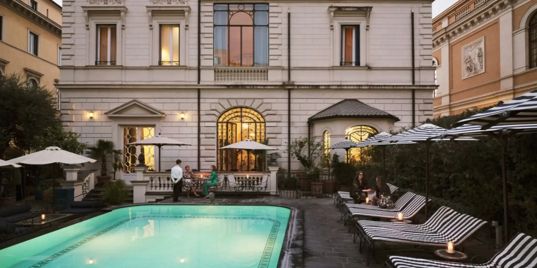 A Hotels.com outdoor pool area with lounge chairs and people relaxing.